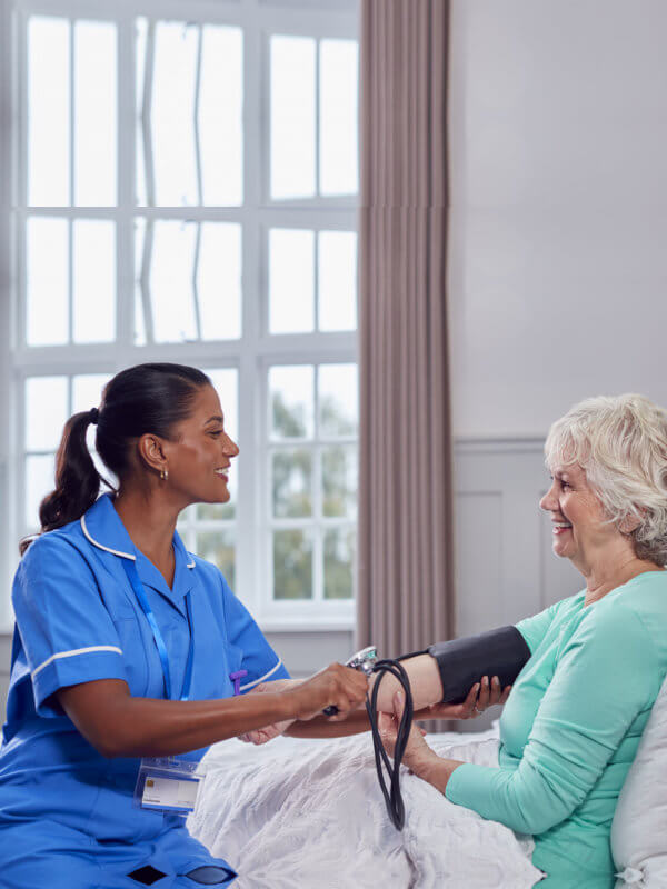 nurse checking blood pressure on eldery