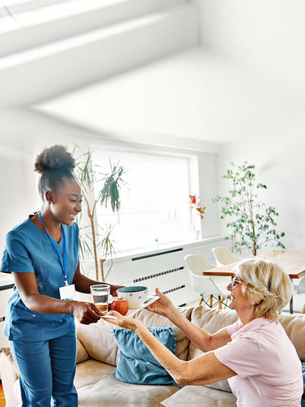 nurse serving to elderly woman