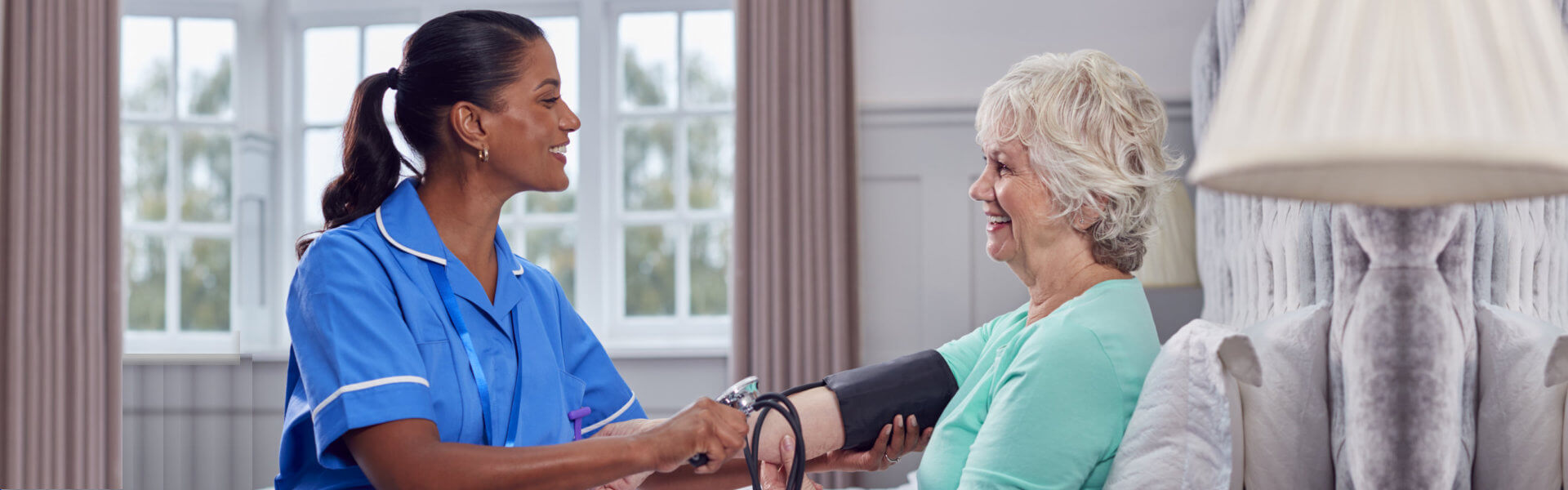 nurse checking blood pressure on eldery
