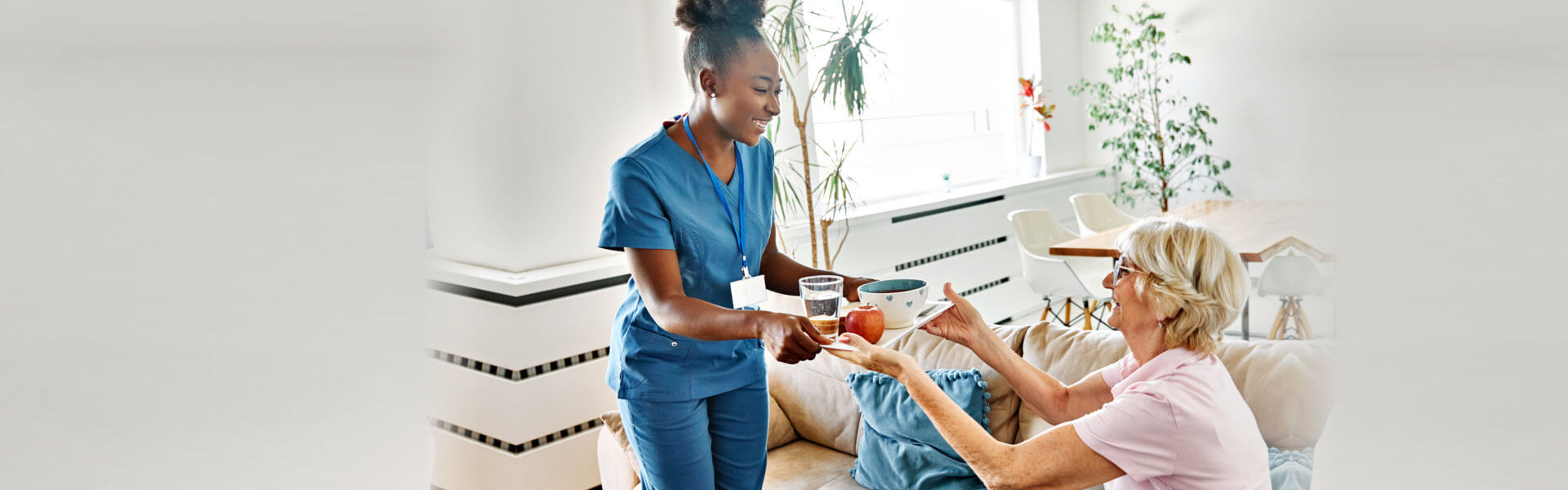 nurse serving to elderly woman